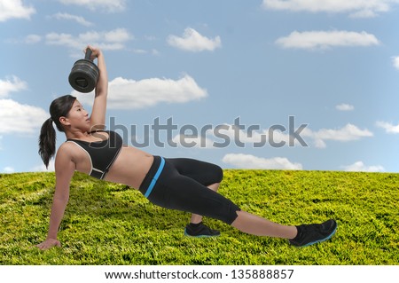 A beautiful young Asian woman using weights during a workout