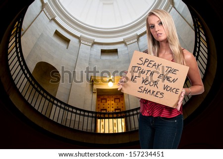 Beautiful young woman holding up an inspirational sign