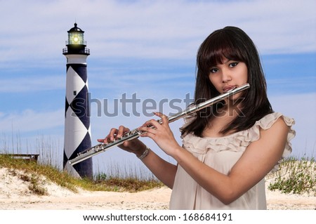 Beautiful young woman playing the musician instrument the flute