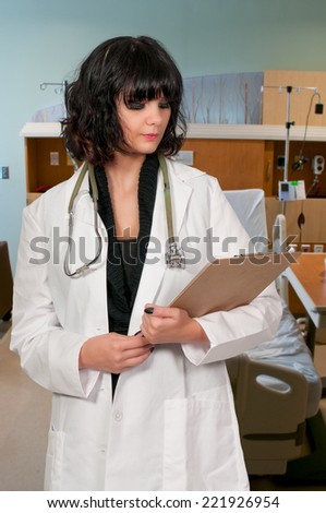 Beautiful young woman doctor in a lab coat holding a patient record