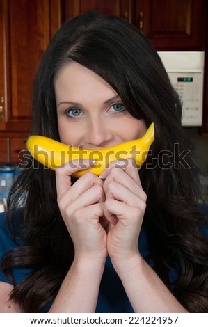 Beautiful woman smiling with a fresh delicious banana