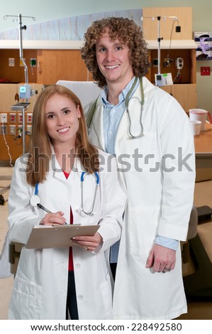 Young man and woman doctor in a lab coat holding a patient record