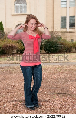 Woman doing the traditional hear no evil gesture