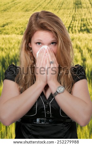 Beautiful woman with a cold, hay fever or allergies blowing her nose