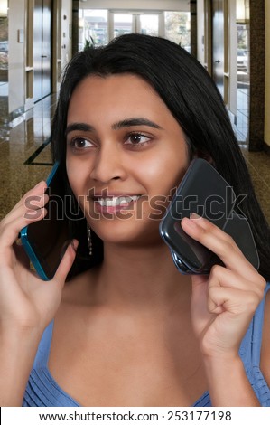 Beautiful woman talking and multitasking while juggling multiple cell phones and conversations
