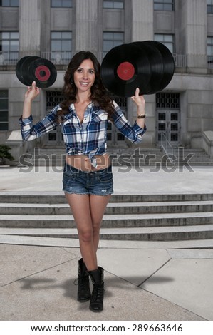 Beautiful woman with vintage 45 vinyl records and record album lps