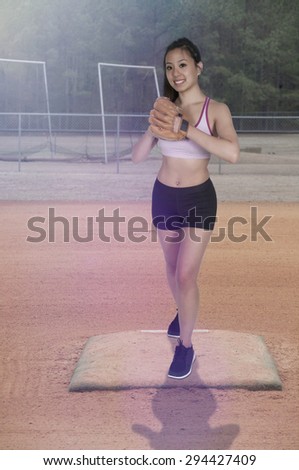 Beautiful woman baseball pitcher getting ready to throw a ball in a game