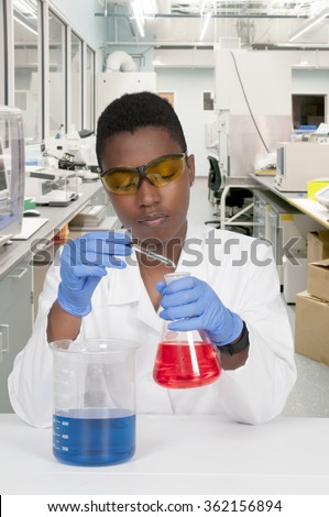 Beautiful woman scientist investigating a glass beaker