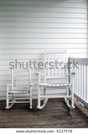 An adult\'s and child\'s rocking chairs on a front porch.