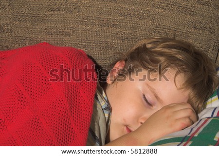 A young boy, with a dirty face, sleeping