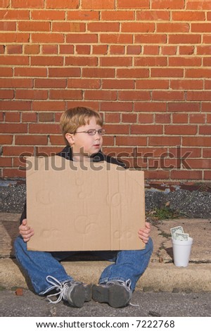 A homeless boy with a blank cardboard sign.