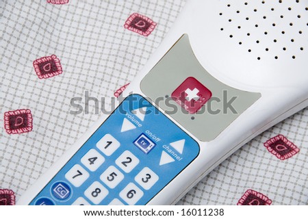 A TV remote control with a nurse call button.