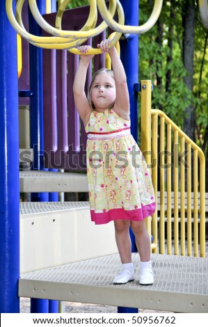 A little girl playing on a jungle gym
