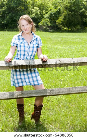 A beautiful country girl standing in a rural setting