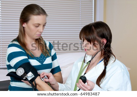 A woman doctor checking a patient blood pressure