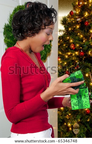 A beautiful young black woman holding a Christmas present