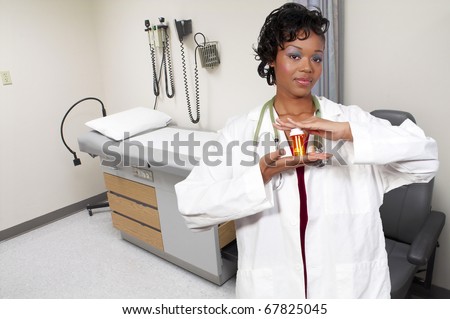 An black woman doctor holding a bottle of prescription pills in a bottle