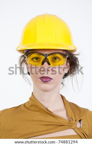 A Female Construction Worker wearing a hard hat and safety glasses