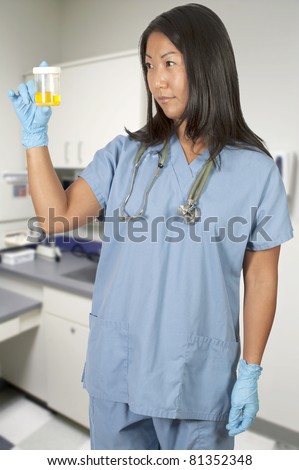 stock-photo-a-beautiful-young-asian-woman-doctor-in-scrubs-holding-a-urine-sample-81352348.jpg
