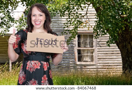 A beautiful young woman holding up a Jesus sign