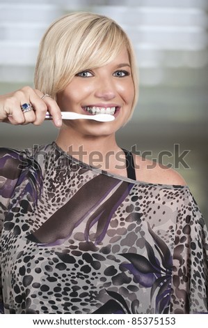 A beautiful woman practicing good oral dental care by brushing her teeth