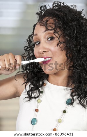 A beautiful black woman practicing good oral dental care by brushing her teeth