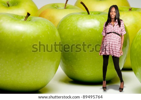 Very happy pregnant black African American woman with some Granny Smith green apples