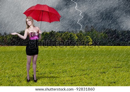 A beautiful young woman holding an umbrella in the rain