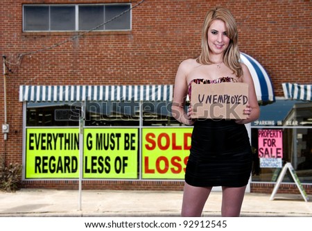 A beautiful young woman holding up an unemployment sign
