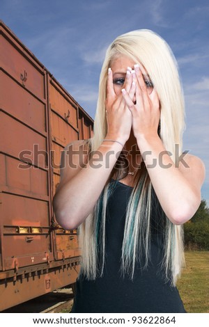 A beautiful young scared or surprised woman looking through her hands