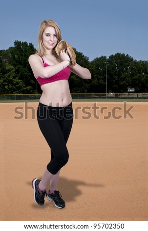 A beautiful woman baseball pitcher getting ready to throw a ball in a game