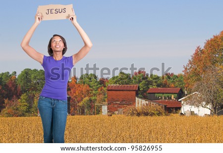 A beautiful young black woman holding up a Jesus sign