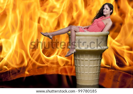 Beautiful woman in an ice cream cone in front of fire