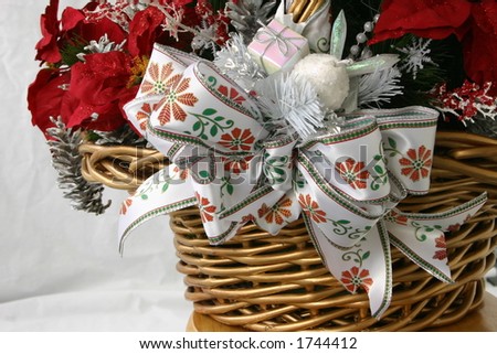 Christmas basket detail with ornaments, ribbon, and poinsettia leaf