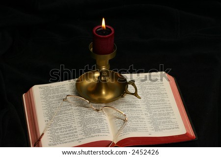 Open Bible (partial Bible) lighted by a candle