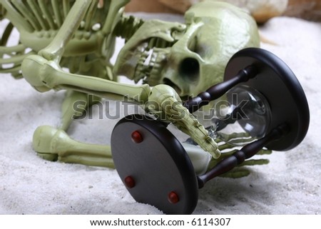 Skeleton holding hourglass indicating that time has run out