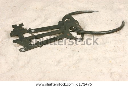 Old skeleton keys on a ring in the sand