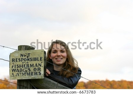 Pretty lady beside weathered sign