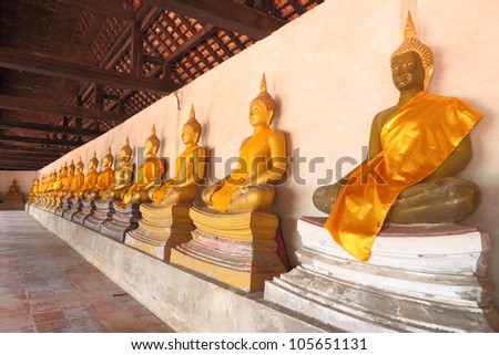 Golden statue of Buddha in shade of church.