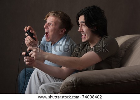 two friends playing video games on gray background