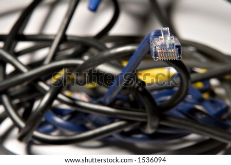 coiled ethernet cable peering out of a wired mess