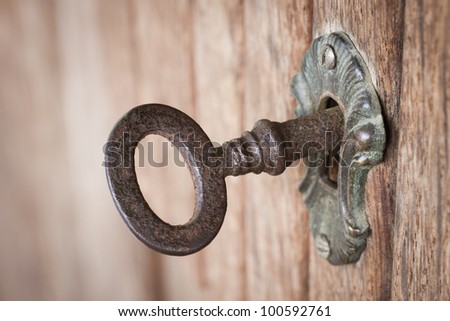 Close-up shot of an old rusty key inside a keyhole