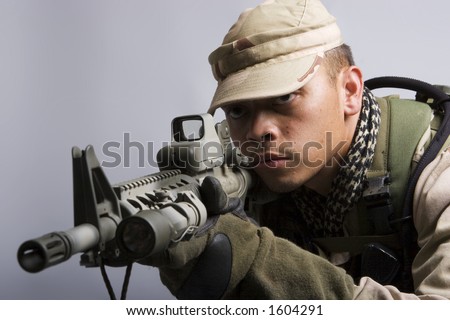 desert storm soldier in the army dressed in camo aiming for shot
