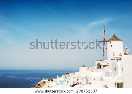 Windmill in Oia town. White architecture on Santorini island, Greece. Beautiful landscape with sea view