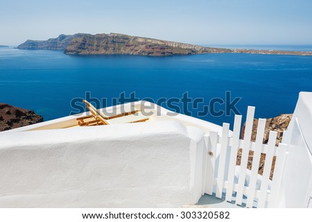 Deck chairs on the terrace with sea view. White architecture on Santorini island, Greece.