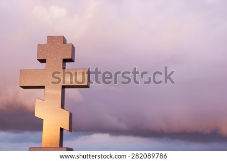 Christian Photo of Large marble Cross standing against Dramatic Sky with colorful clouds