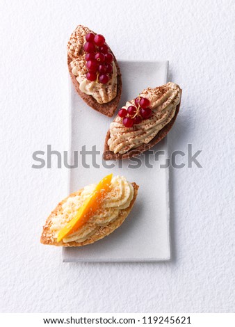 Tartlets with cream, red currant, and mango