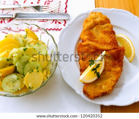 Wiener Schnitzel. Breadcrumbed and fried veal scallop with potato and cucumber salad