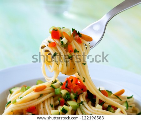 Spaghetti on fork with sauce and parsley