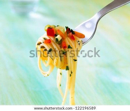 Spaghetti on fork with sauce and parsley